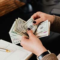 hands flipping through cash dollars